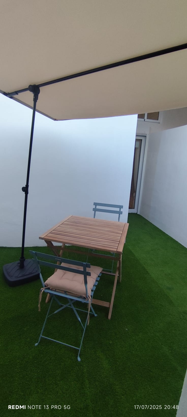 Patio privado con césped artificial y mesa de exterior